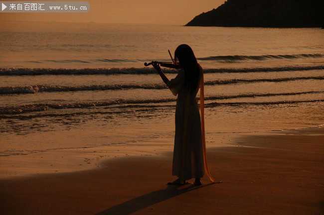 海边拉小提琴的美女