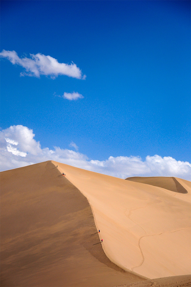 蓝天下敦煌沙漠徙步背景图片