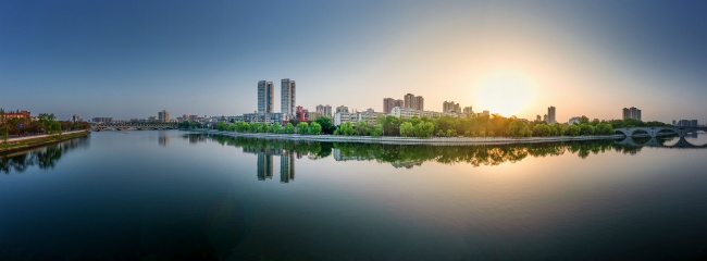 宽幅倒影在水中的城市日出全景