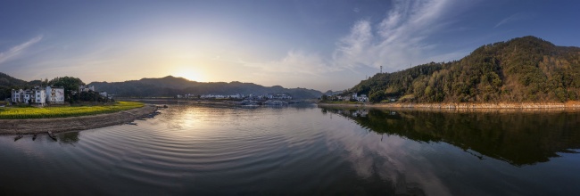 宽幅日落时分湖光山色下的静谧村庄风景图片