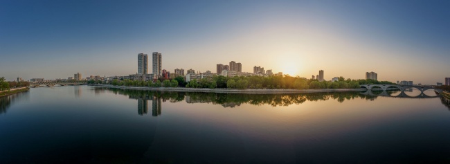 宽幅城市水岸的宁静日出全景摄影图片