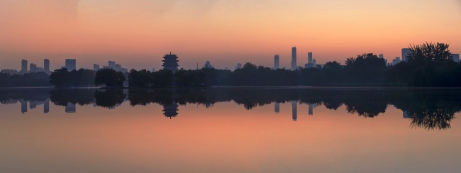 城市日出湖面倒影全景
